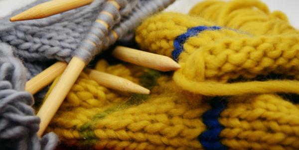 knitting needles with yarn on grey and golden yellow w/blue stripe projects