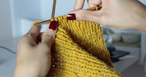 hands knitting yellow project with knitting needles